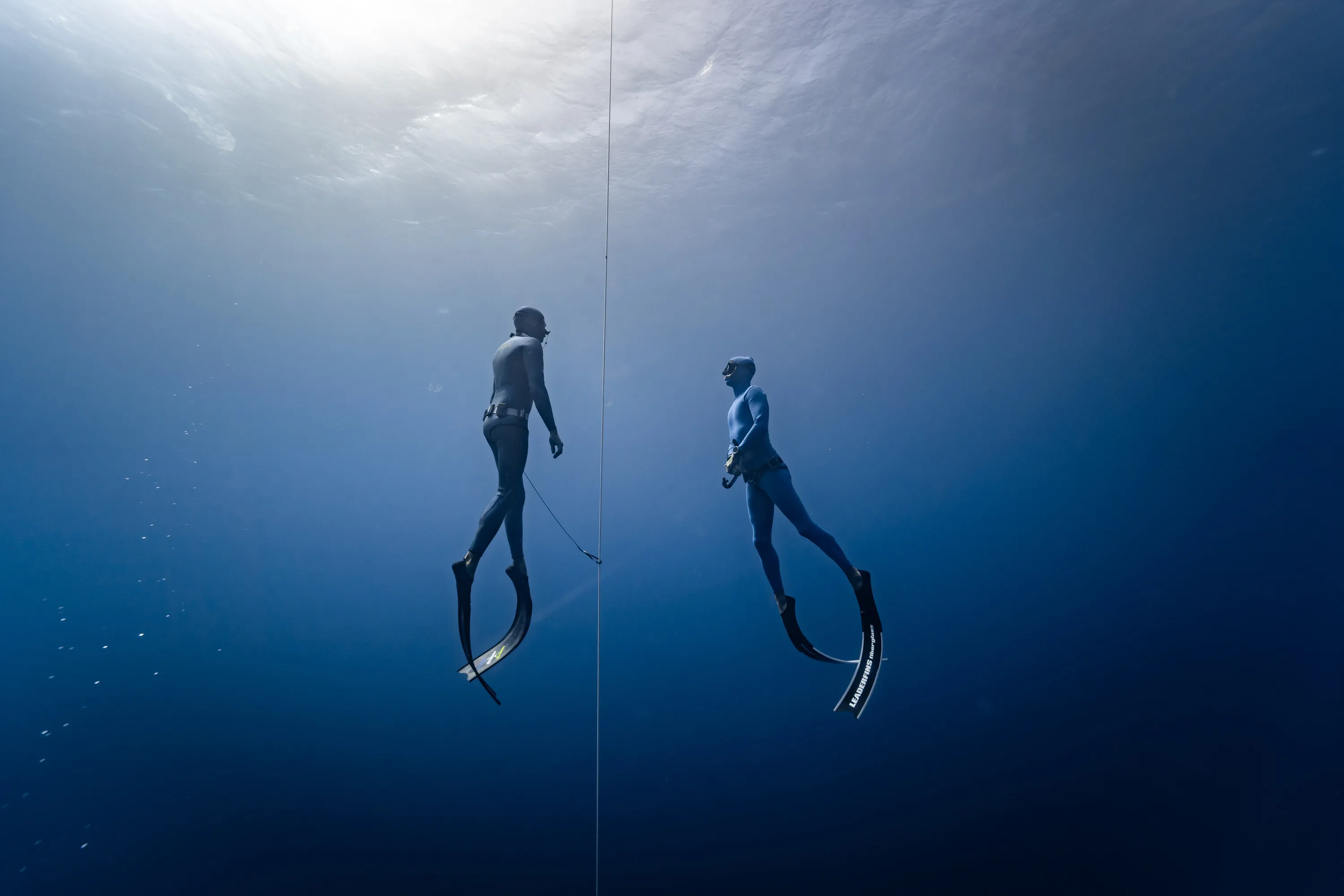 A freediver and his safety buddy are ascending from depth