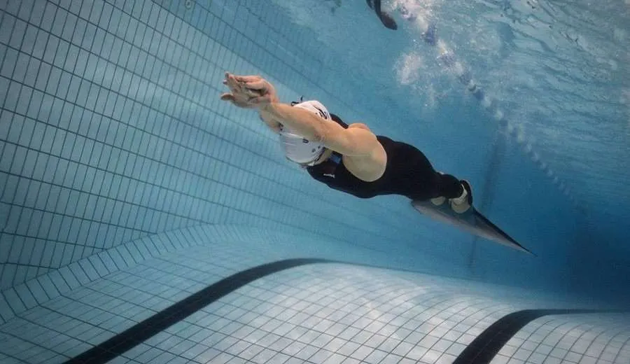 A freediver is training dynamic training in the pool in Dubai, UAE.