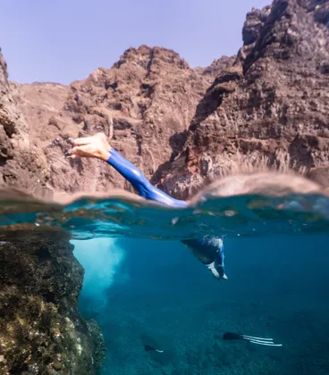 A freediver jumping into the water in one of the travels